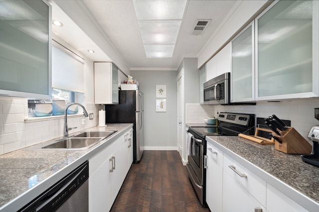 kitchen with visible vents, a sink, appliances with stainless steel finishes, crown molding, and baseboards