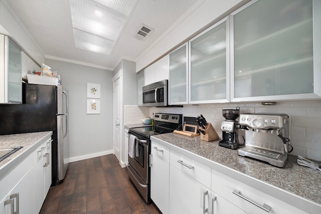 kitchen featuring visible vents, glass insert cabinets, crown molding, decorative backsplash, and stainless steel appliances