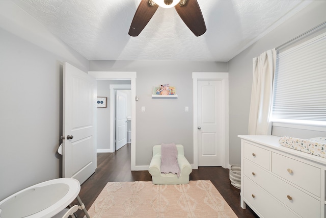 bedroom with ceiling fan, baseboards, dark wood-style flooring, and a textured ceiling