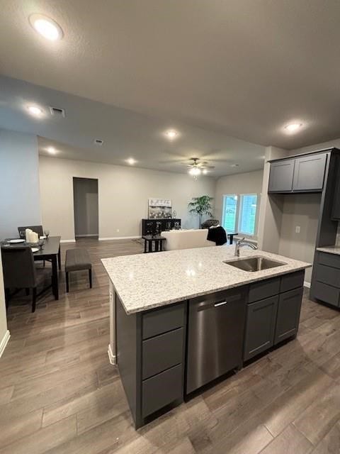 kitchen with visible vents, light wood-style flooring, an island with sink, a sink, and stainless steel dishwasher