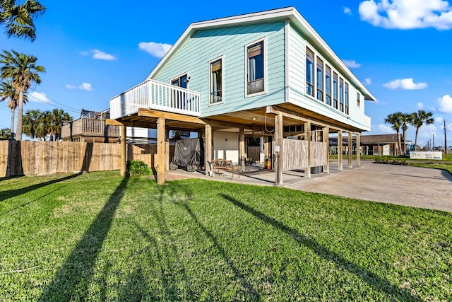 back of house featuring a yard, a patio, and fence