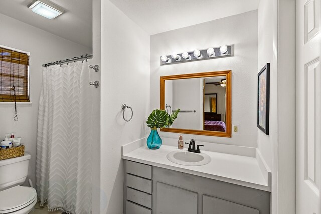 bathroom with curtained shower, toilet, and vanity