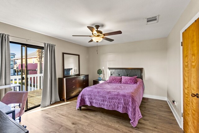 bedroom featuring access to outside, wood finished floors, visible vents, and baseboards