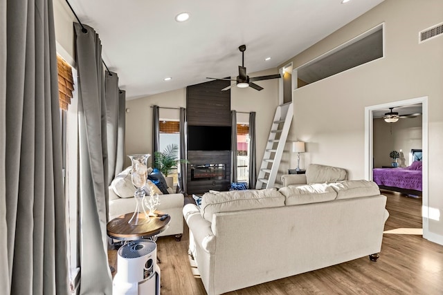 living area with a ceiling fan, wood finished floors, visible vents, lofted ceiling, and recessed lighting