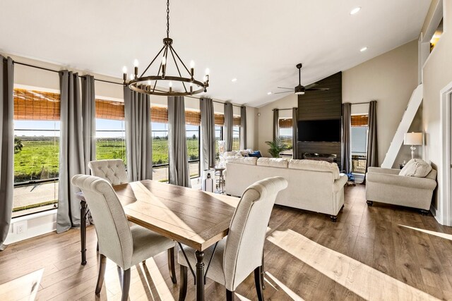 dining room featuring ceiling fan with notable chandelier, recessed lighting, wood-type flooring, and high vaulted ceiling