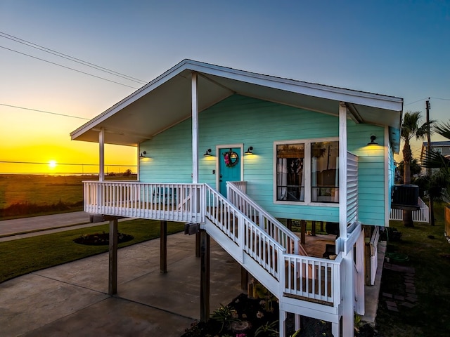 view of front of property featuring stairs, cooling unit, and covered porch