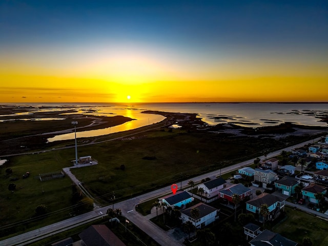 aerial view at dusk featuring a water view