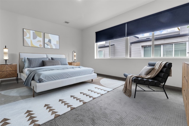 carpeted bedroom with multiple windows, baseboards, and visible vents