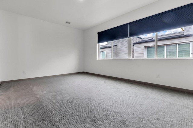 carpeted empty room featuring visible vents and baseboards