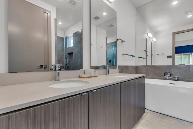 full bathroom featuring double vanity, visible vents, a stall shower, and a sink