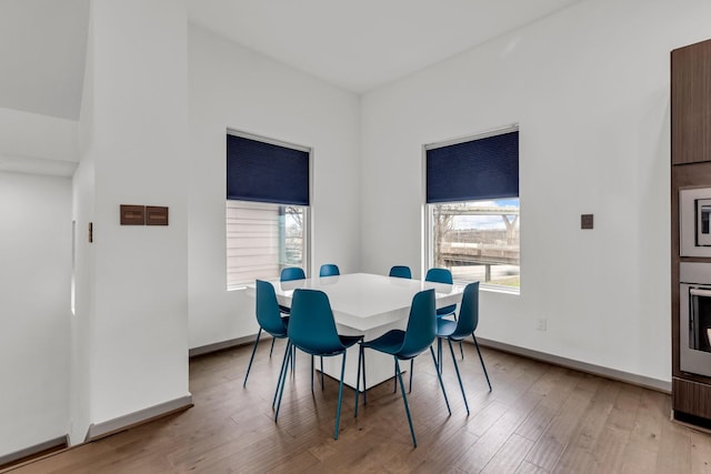 dining area featuring light wood finished floors and baseboards