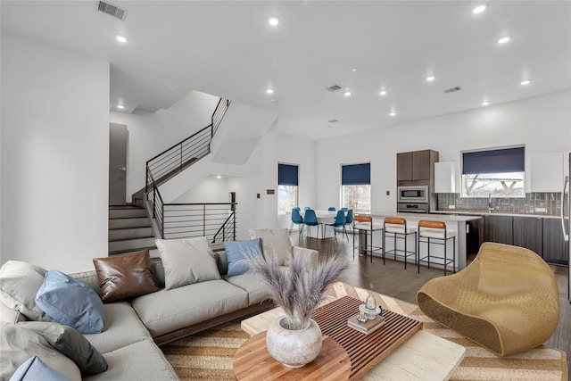 living area with visible vents, recessed lighting, and stairway