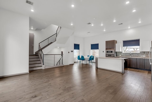 kitchen featuring visible vents, a center island, decorative backsplash, appliances with stainless steel finishes, and wood finished floors