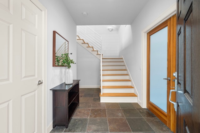 entryway featuring french doors, baseboards, stone tile flooring, and stairs