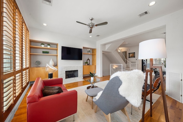 living area featuring recessed lighting, a fireplace with flush hearth, wood finished floors, and visible vents