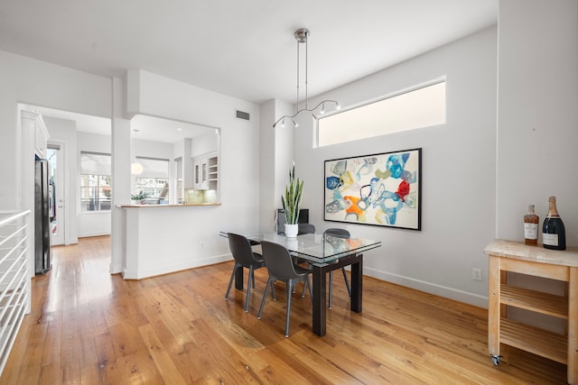 dining area featuring visible vents, light wood-style floors, and baseboards