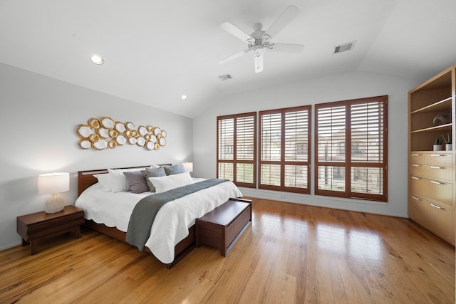 bedroom featuring visible vents, light wood-style flooring, and vaulted ceiling