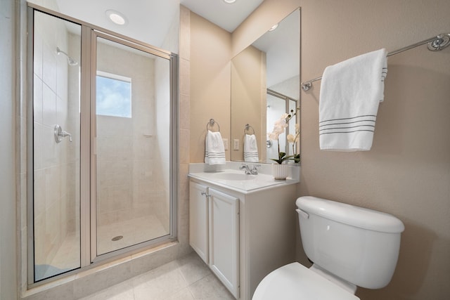 bathroom featuring tile patterned flooring, a stall shower, toilet, and vanity