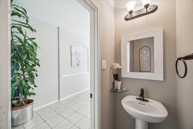 bathroom featuring tile patterned flooring, baseboards, and a sink