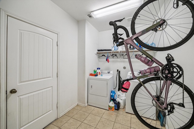 laundry area with light tile patterned floors, visible vents, separate washer and dryer, and laundry area