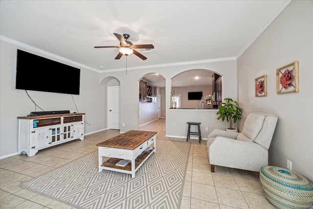 living room featuring ceiling fan, arched walkways, light tile patterned flooring, and ornamental molding