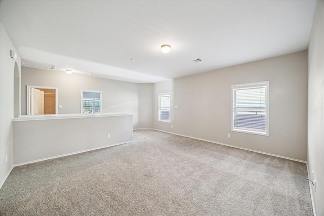 spare room with baseboards and carpet