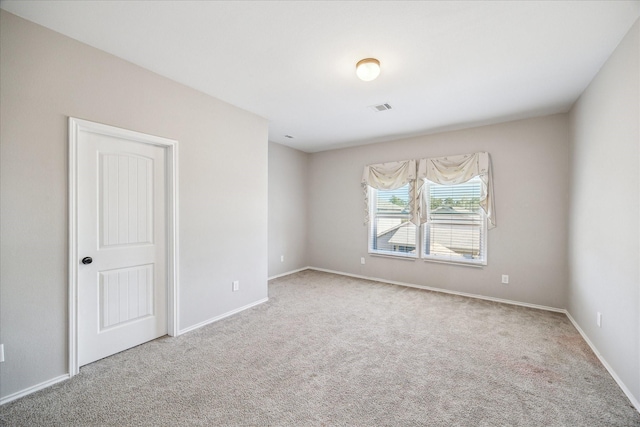 unfurnished room with visible vents, baseboards, and carpet