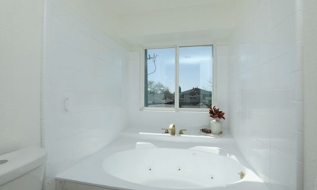 bathroom with toilet and a whirlpool tub