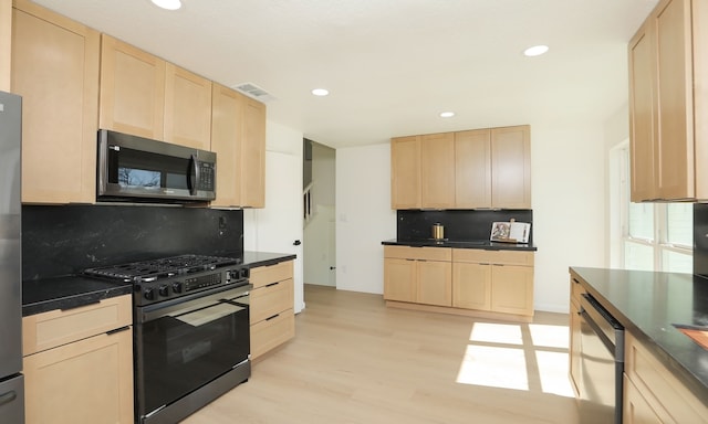 kitchen with dark countertops, visible vents, light brown cabinetry, decorative backsplash, and stainless steel appliances