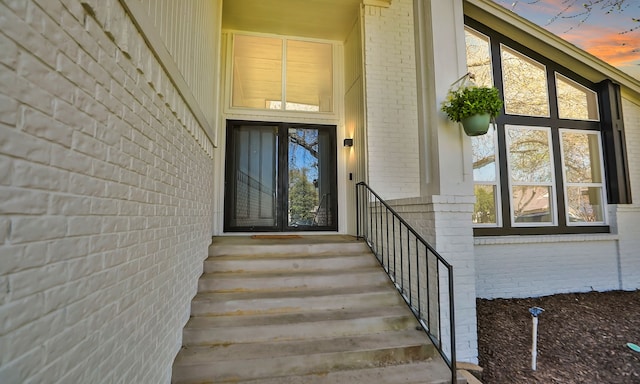 doorway to property featuring brick siding