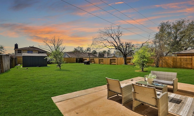 yard at dusk featuring a patio area, a fenced backyard, and an outdoor structure