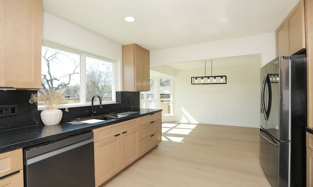 kitchen featuring dark countertops, backsplash, light brown cabinets, and stainless steel appliances