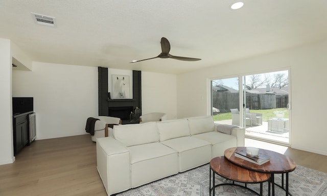 living room with a ceiling fan, visible vents, baseboards, recessed lighting, and light wood-style floors