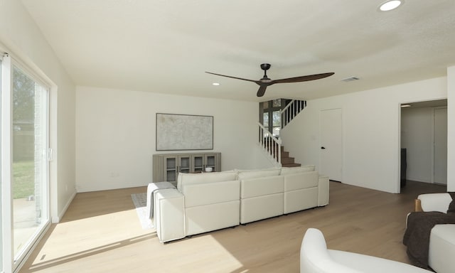 living area featuring light wood finished floors, visible vents, ceiling fan, stairway, and recessed lighting