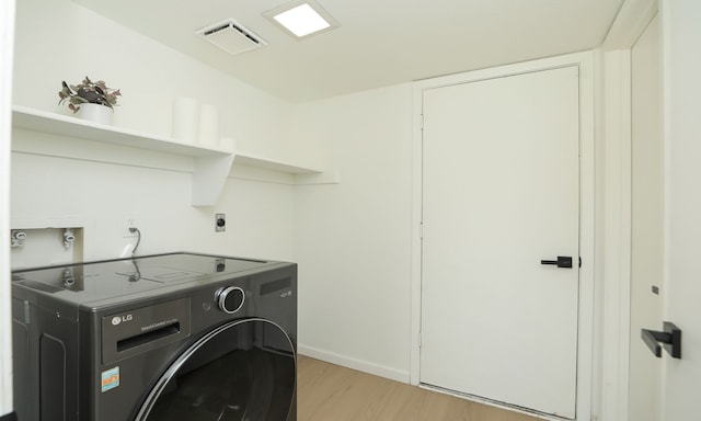 laundry area featuring laundry area, light wood-style flooring, washer / clothes dryer, and visible vents