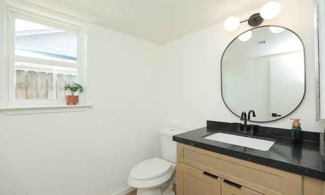 bathroom featuring vanity, toilet, and visible vents