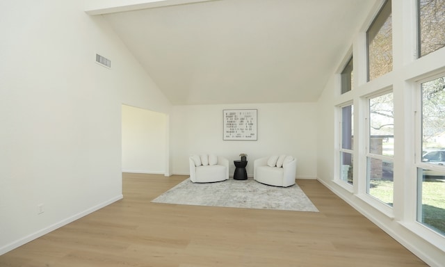 unfurnished room featuring visible vents, high vaulted ceiling, light wood-type flooring, and baseboards