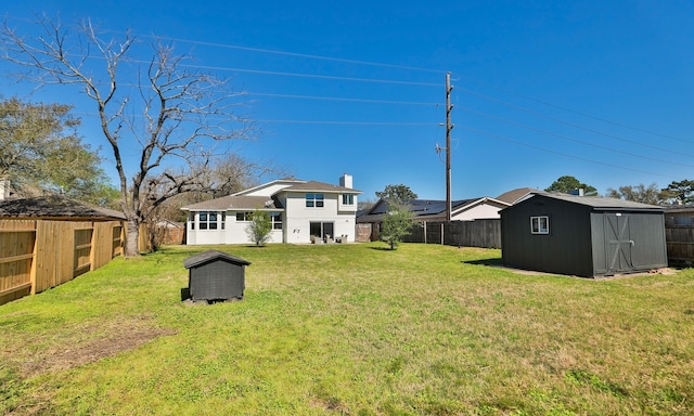 view of yard with a storage unit, an outdoor structure, and a fenced backyard