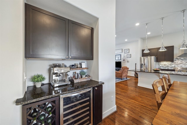 bar with stainless steel refrigerator with ice dispenser, tasteful backsplash, wine cooler, a dry bar, and dark wood-style flooring