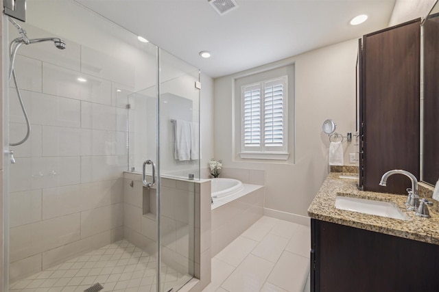 full bathroom with visible vents, a garden tub, a sink, a shower stall, and double vanity