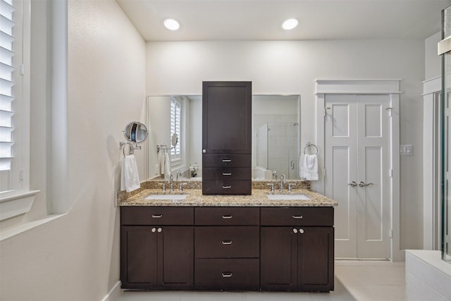 full bathroom featuring double vanity, recessed lighting, a shower stall, and a sink