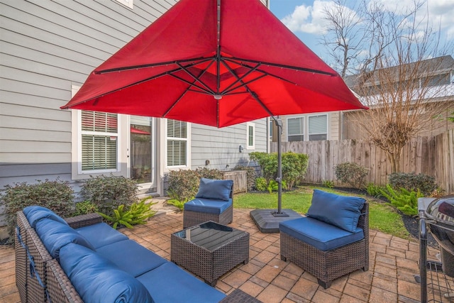 view of patio with an outdoor living space and fence