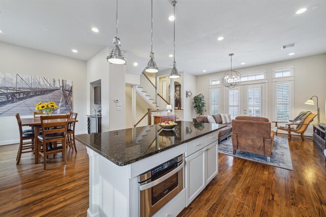 kitchen with a center island, dark stone countertops, recessed lighting, white cabinets, and dark wood-style flooring