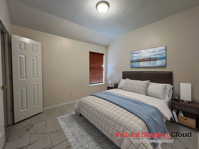 bedroom featuring marble finish floor, a textured ceiling, baseboards, and lofted ceiling