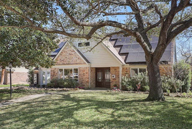 18531 Point Lookout Dr, Houston, TX 77058 - view of front of house with french doors, a front yard, brick siding, and roof mounted solar panels