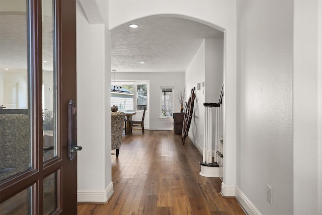 18531 Point Lookout Dr, Houston, TX 77058 - hall with baseboards, arched walkways, and dark wood-style floors