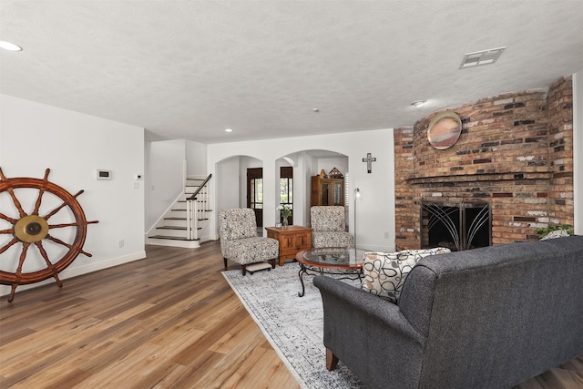 18531 Point Lookout Dr, Houston, TX 77058 - living room with arched walkways, wood finished floors, baseboards, stairway, and a textured ceiling