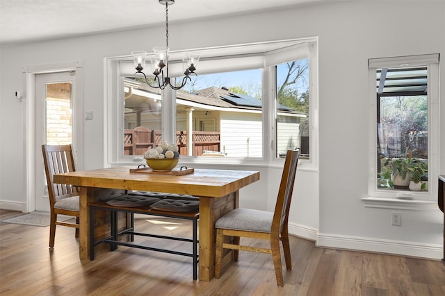18531 Point Lookout Dr, Houston, TX 77058 - dining area with a chandelier, wood finished floors, baseboards, and plenty of natural light