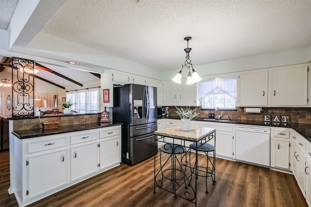 kitchen featuring dark wood-style flooring, a sink, white cabinets, dishwasher, and stainless steel fridge