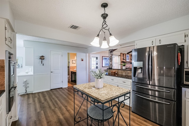 kitchen featuring visible vents, dark wood-type flooring, a textured ceiling, white cabinetry, and appliances with stainless steel finishes